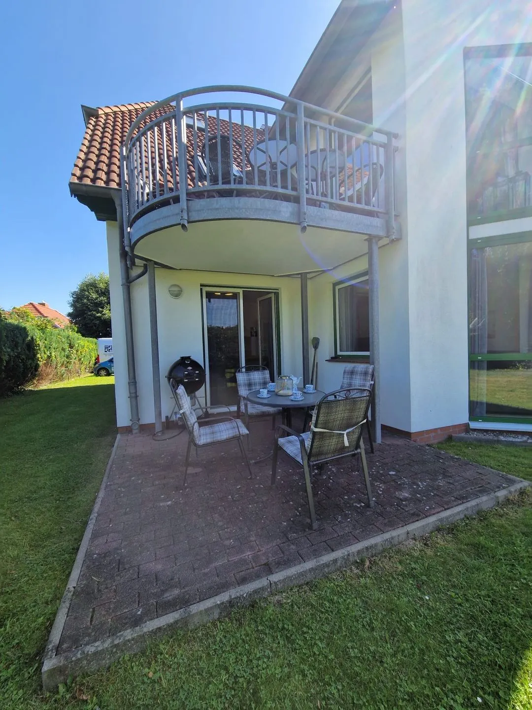 Außenansicht des Hauses mit Terrasse im Erdgeschoss und Rasen