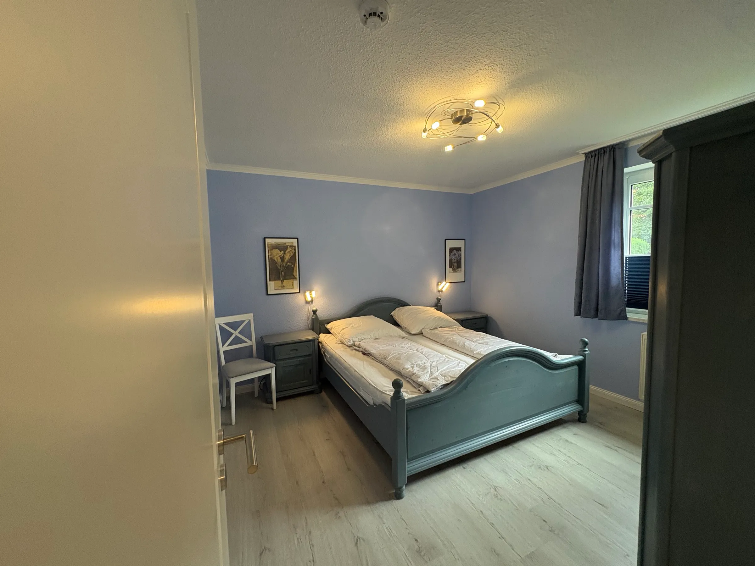 Schlafzimmer in Hellblau mit Doppelbett und Nachttischlampen